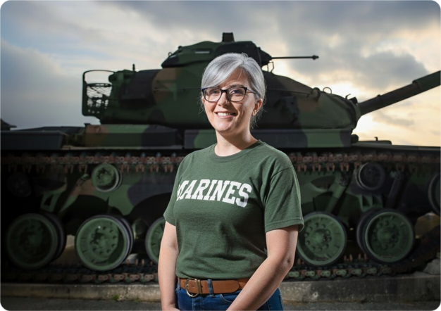 Female veteran in front of tank